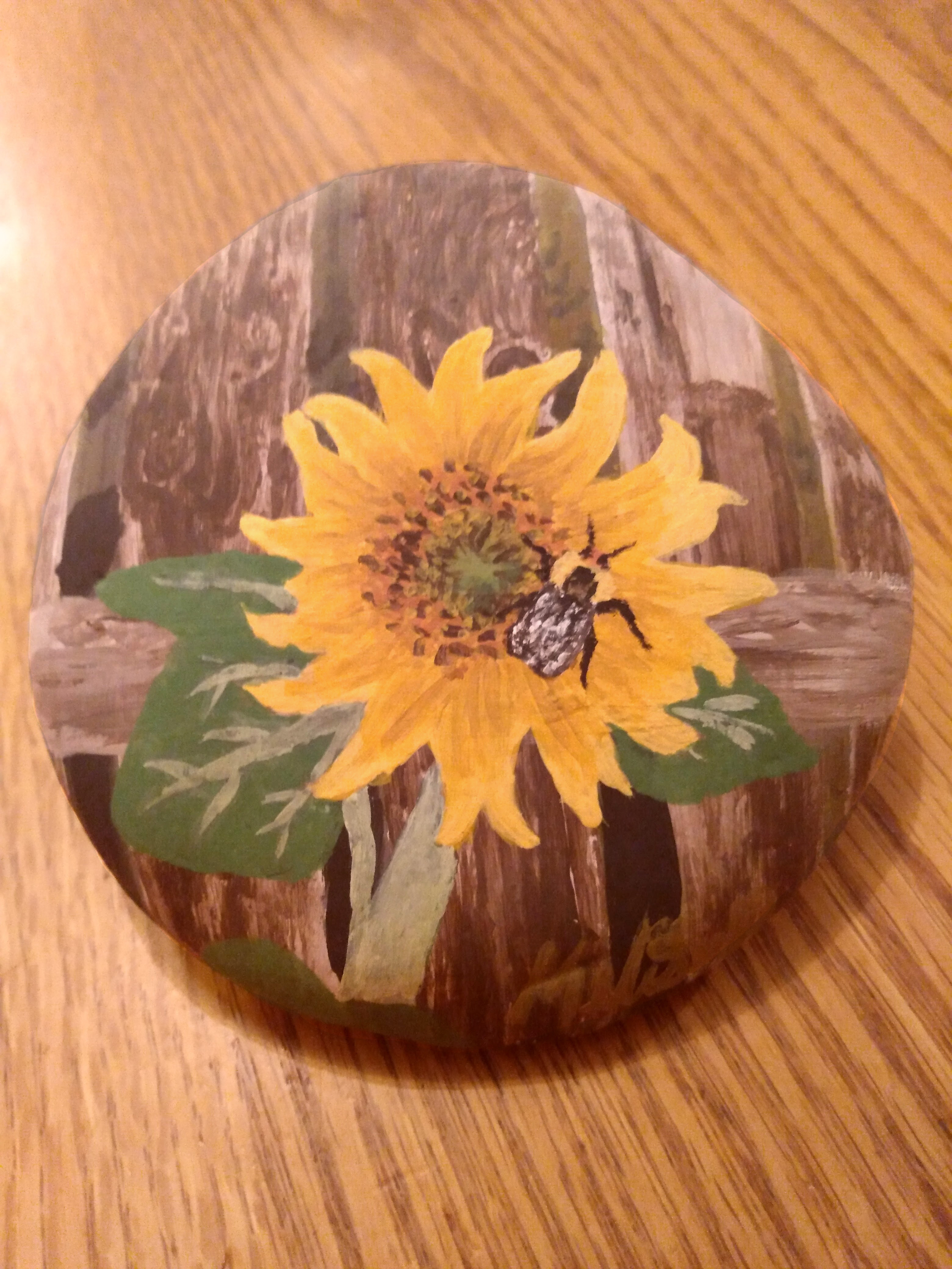 Sunflower and bee painted on a rock
